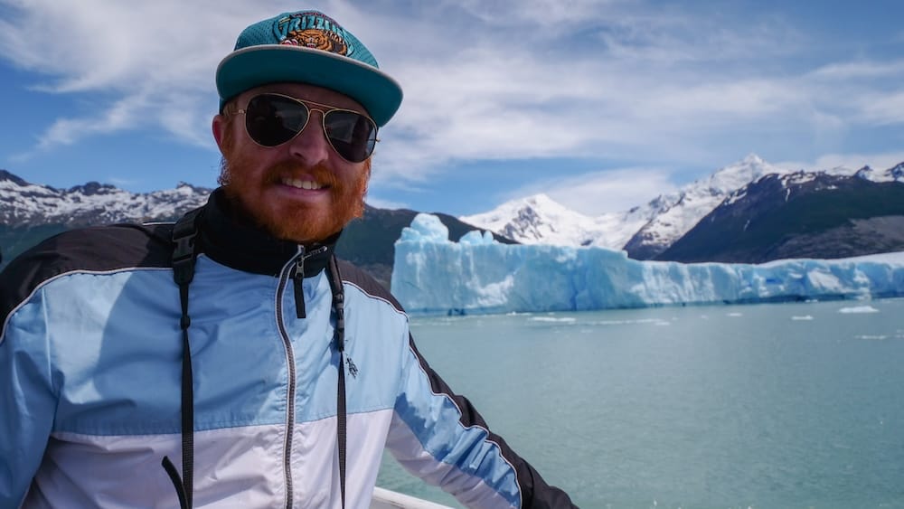 Samuel Jeffery on the Perito Moreno Glacier boat cruise, El Calafate, Santa Cruz Province, Patagonia Samuel Jeffery smiles aboard a boat cruise near the Perito Moreno Glacier in El Calafate, Santa Cruz Province, Argentine Patagonia, with blue ice walls and snow-capped Andean peaks behind him.
