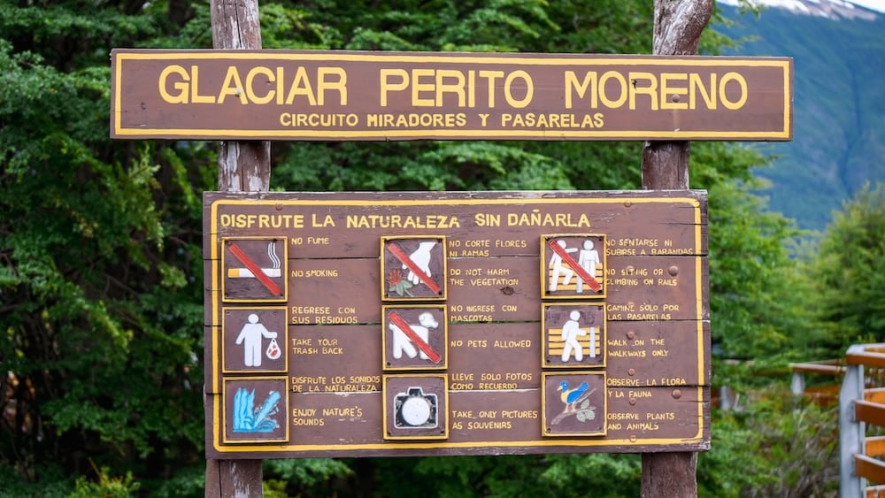 Responsible tourism and walkway rules sign at Perito Moreno Glacier in Patagonia, Argentina A bilingual sign at Perito Moreno Glacier in Santa Cruz, Patagonia, Argentina, lists walkway rules and responsible tourism guidance, including no smoking, no pets and protection of native plants and wildlife.