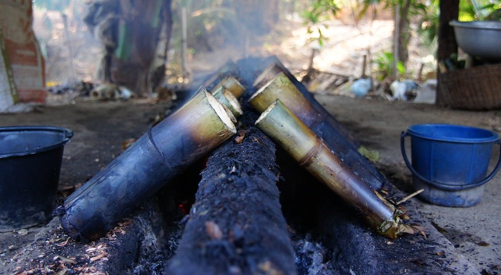 Preparing traditional bamboo over the fire in Battambang, Cambodia 