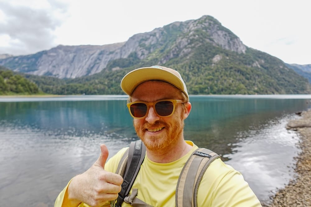 Samuel Jeffery at Puerto Blest in Nahuel Huapi, Río Negro, Patagonia, Argentina Samuel Jeffery gives a thumbs-up beside the calm lake at Puerto Blest, with forested mountain slopes rising behind him in Nahuel Huapi, Río Negro, Patagonia, Argentina.