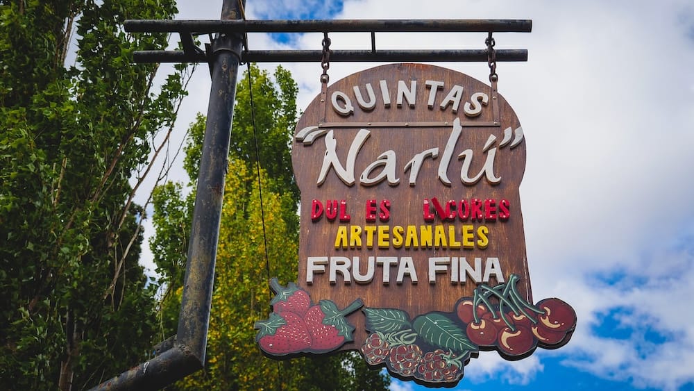 Quintas Narlú Gaiman Patagonia orchard sign artisanal sweets fruit Welsh tea hidden spot Argentina Rustic wooden sign for Quintas Narlú orchard in Gaiman Patagonia Argentina advertising artisanal sweets and fine fruit, marking a hidden local destination offering a more authentic and off-the-beaten-path Welsh tea experience
