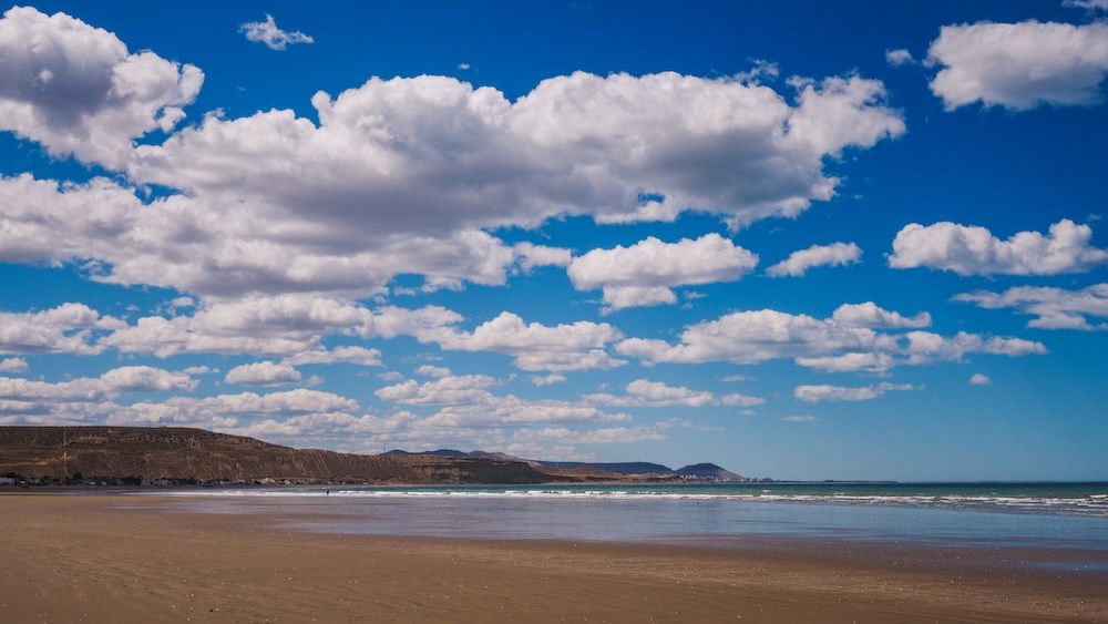 Wide sandy beach and big sky landscape in Rada Tilly Patagonia Argentina Rada Tilly wide beach along the Atlantic coast of Patagonia in Chubut Argentina where vast tidal flats, open horizons, and dramatic cloud filled skies create one of the most expansive coastal landscapes in southern Patagonia.