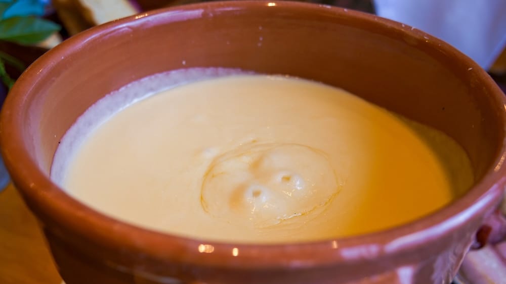 Traditional Cheese Fondue at Restaurante Patagonia, Llao Llao Hotel, Bariloche, Río Negro, Patagonia, Argentina Close-up of a clay pot filled with traditional cheese fondue at Restaurante Patagonia in Llao Llao Hotel, Bariloche, Río Negro, Patagonia, Argentina, showing the smooth melted cheese served as a shared alpine-style meal.