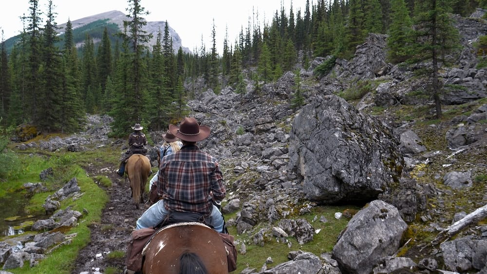 Riding trail between Sundance Lodge and Halfway Lodge, Banff National Park, Alberta, Canada Riders on horseback follow a rocky backcountry trail between Sundance Lodge and Halfway Lodge in Banff National Park, Alberta, Canada, during a multi-day Banff Trail Riders horseback trek.
