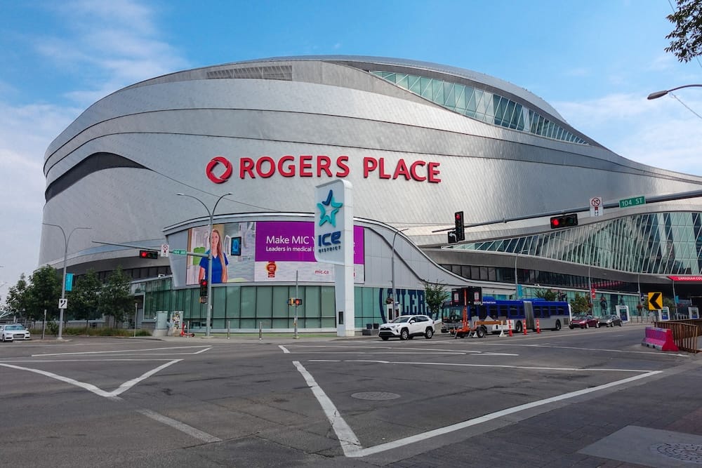 Rogers Place Exterior at 104 Street, ICE District, Edmonton, Alberta, Canada Exterior view of Rogers Place arena from the corner of 104 Street in downtown Edmonton, with the ICE District sign and passing traffic in the foreground, Alberta, Canada.
