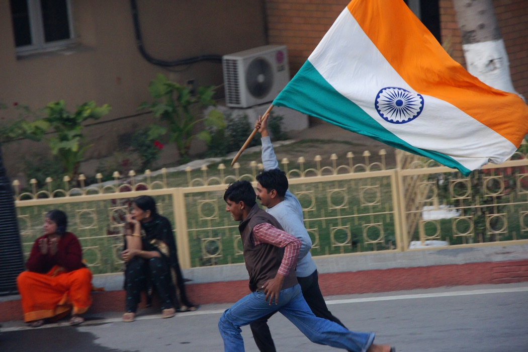 Running as fast as they can with the Indian flag flapping in the back at the India Pakistan border closing ceremony
