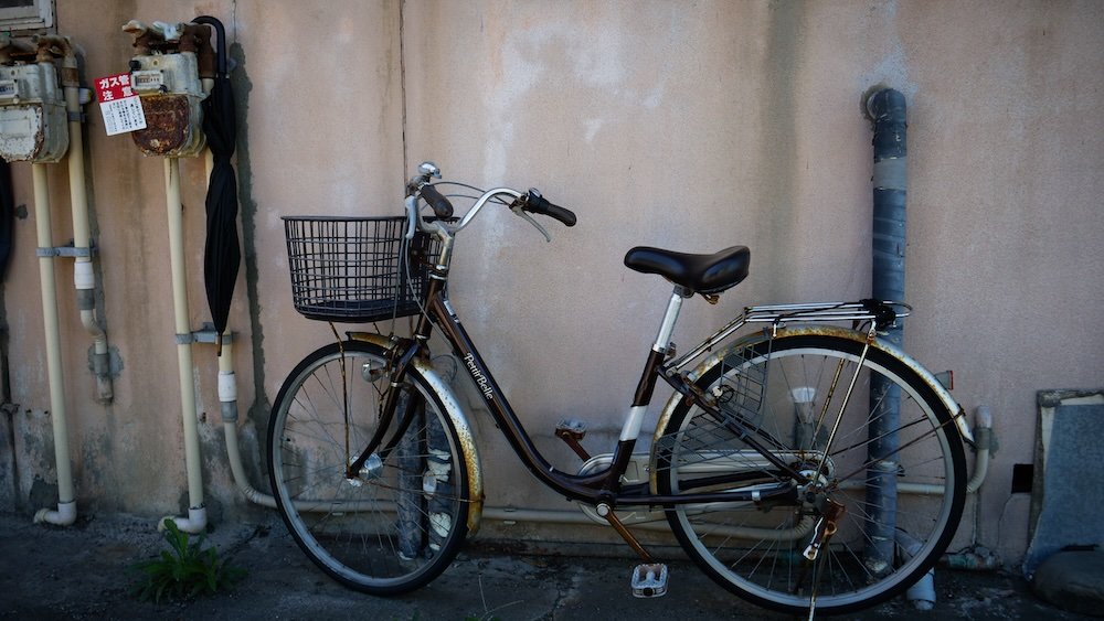 Rustic and rusted bicycle in Niigata, Japan parked against a wall