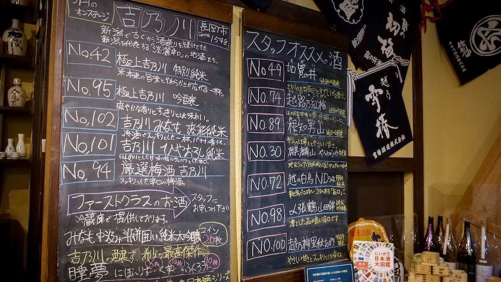 Sake menu written on the board in Japanese characters tasting options 