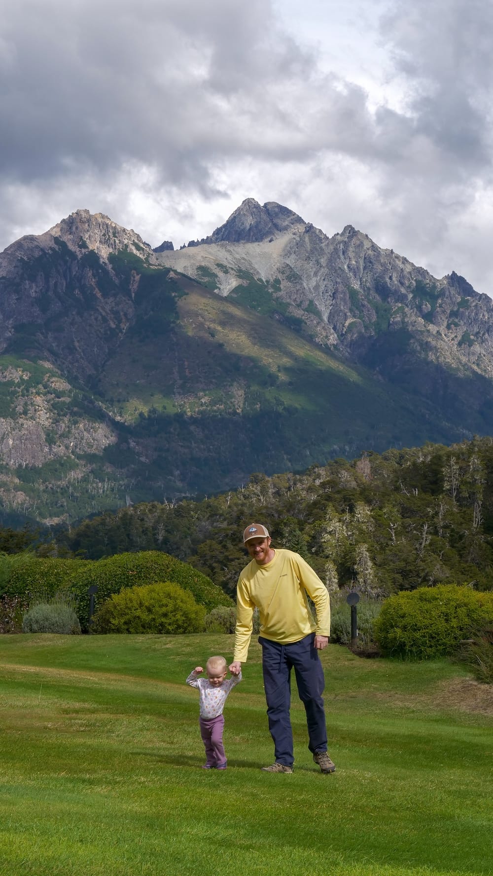 Samuel and Aurelia Jeffery Walking at Llao Llao Hotel in Bariloche, Patagonia Samuel Jeffery holds toddler Aurelia Jeffery’s hand as they walk across the lawn at Llao Llao Hotel beneath the mountains near Bariloche, Río Negro.