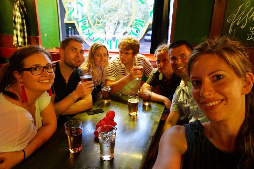 Samuel Jeffery, Audrey Bergner and friends gathered around a pub table with glasses of Finnish beer during a social evening in Helsinki, capturing the relaxed group side of our food and drink experiences in Finland.
