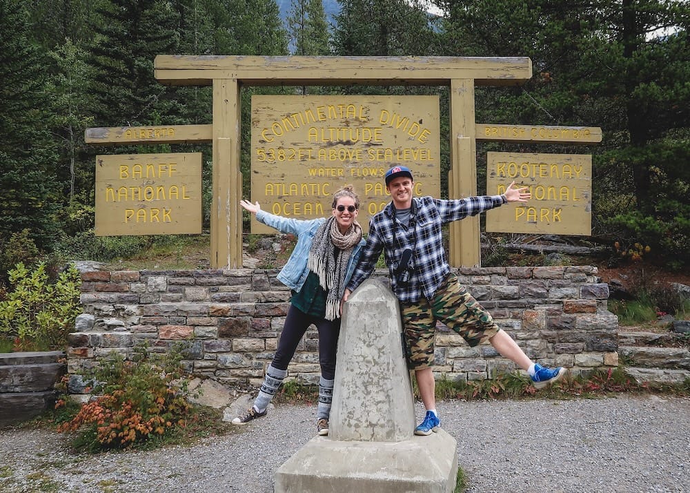 Samuel Jeffery and Audrey Bergner at the Continental Divide survey marker, Banff and Kootenay National Parks Samuel Jeffery and Audrey Bergner pose beside the stone survey marker at the Continental Divide sign, with the Banff National Park and Kootenay National Park boundary signage visible behind them.