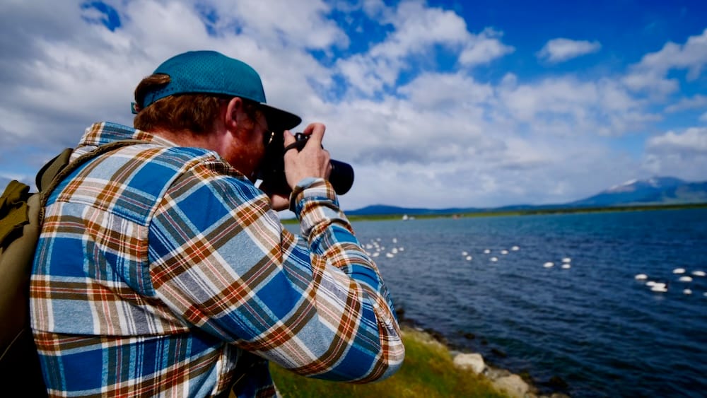 Samuel Jeffery photographs birds along the windy Última Esperanza waterfront in Puerto Natales, Chile, where Patagonia’s weather and open landscapes shape every travel day.