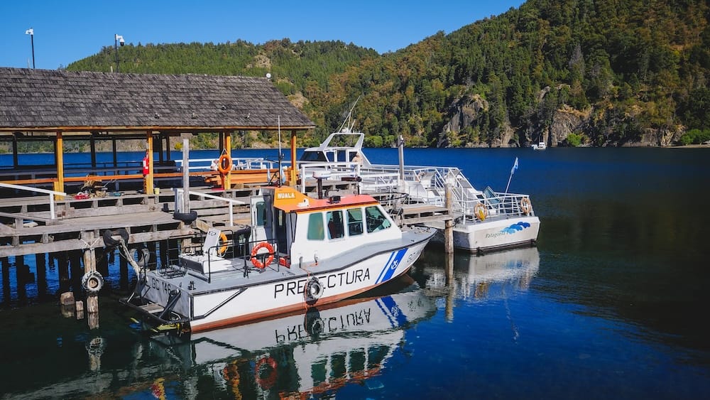 San Martin de los Andes lake dock with boats in Patagonia Argentina Boats docked at a pier in San Martin de los Andes Patagonia Argentina on a calm lake surrounded by forested hills, showing everyday life and transport in the region
