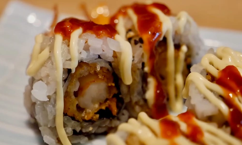 Spicy shrimp roll, Shoku Izakaya, Banff, Alberta, Canada Close-up of spicy shrimp sushi rolls topped with mayo and spicy sauce drizzle at Shoku Izakaya in Banff, Alberta, Canada.