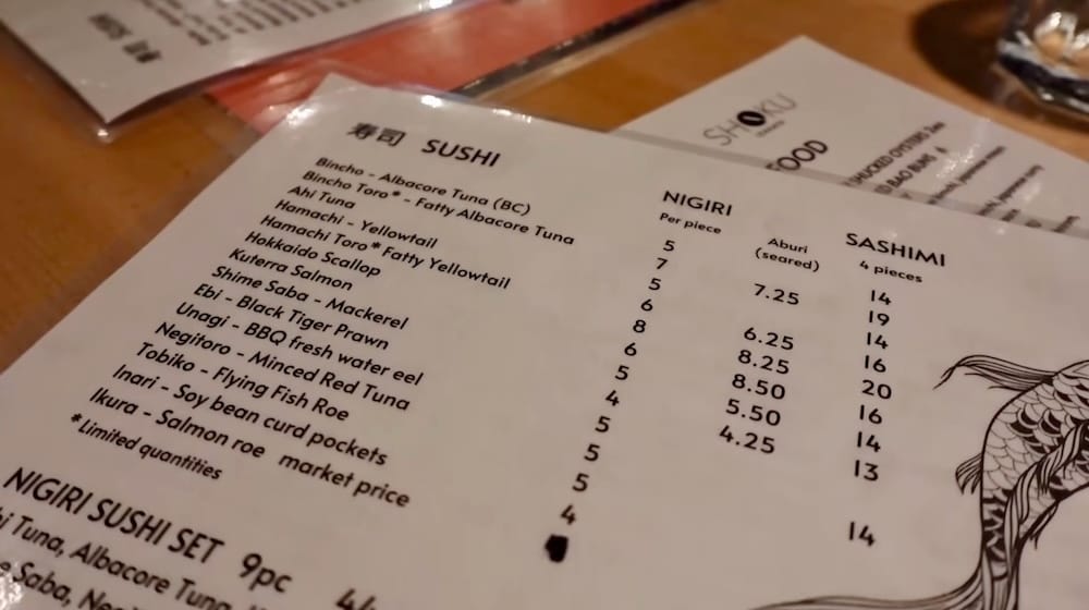 Sushi and sashimi menu detail, Shoku Izakaya, Banff, Alberta Close-up of the sushi, nigiri, and sashimi menu page at Shoku Izakaya in Banff, Alberta, Canada, listing options like bincho tuna, hamachi, and unagi with per-piece pricing.