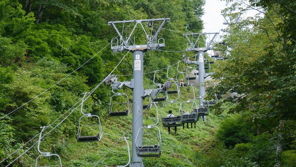 Ski Lift Going Up Lush Green Forest In Yuzawa Kogen Botanic Garden in Yuzawa, Niigata, Japan