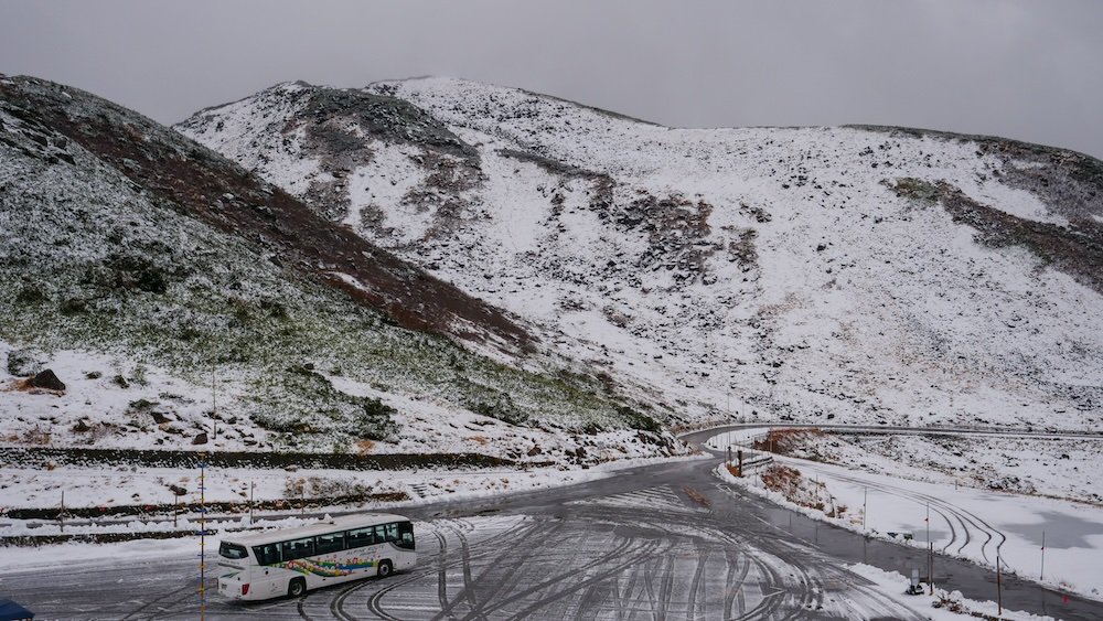 Snow capped epic mountains and serpentine roads and bus route on the Tateyama Kurobe Alpine Route