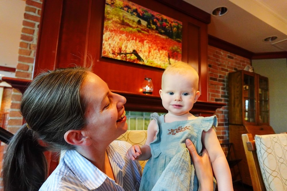St. Eugene Golf Resort & Casino in Cranbrook, British Columbia, showing Audrey Bergner sharing a warm family moment with baby Aurelia indoors, capturing the relaxed atmosphere of the historic resort during a calm and memorable family stay.
