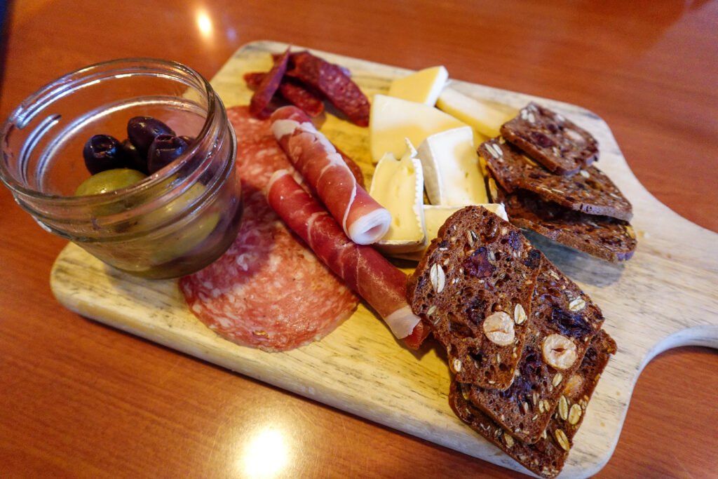 St. Eugene Golf Resort & Casino in Cranbrook, British Columbia, showing a charcuterie board at Numa Lounge & Dining with cured meats, cheeses, olives, and crackers, highlighting an easy-to-share option well suited to dining with a baby.