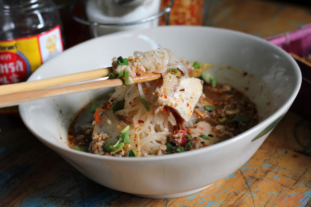 Thai soup with noodles Thai food as lifted up by chopsticks 