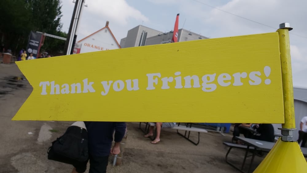 "Thank You Fringers!" sign at the Edmonton Fringe Festival, Old Strathcona, Alberta, Canada A yellow "Thank You Fringers!" sign points toward the Edmonton Fringe Festival grounds in Old Strathcona, Edmonton, Alberta, Canada, with picnic tables and festivalgoers in the background.