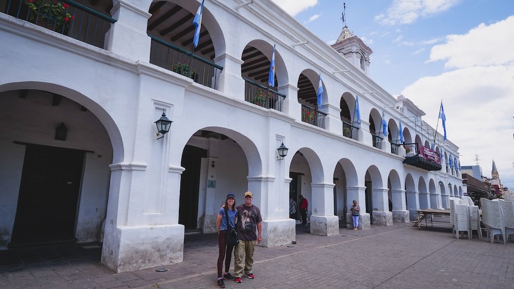 That Backpacker Audrey Bergner and Daniel Bergner standing outside of the the Cabildo and Historical Museum of the North of Plaza 9 de Julio in Salta, Argentina