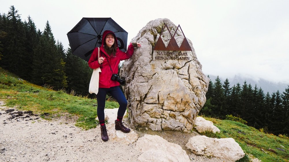 That Backpacker Audrey Bergner posing by the Berchtesgaden National Park rock monument on a rainy day in Germany