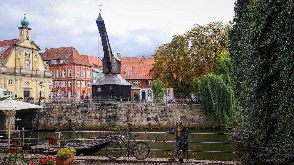 That Backpacker Audrey Bergner posing by the Ilmenau River and the Old Crane in Luneburg old town of Germany