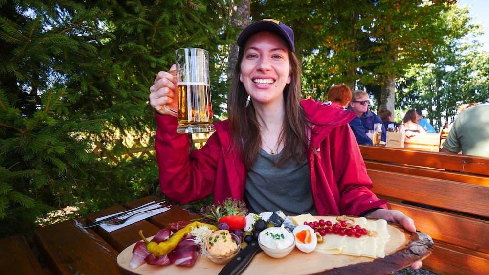 That Backpacker Audrey Bergner thrilled to be feasting on snacks and beer in Gaisberg after a big hike in Austria 