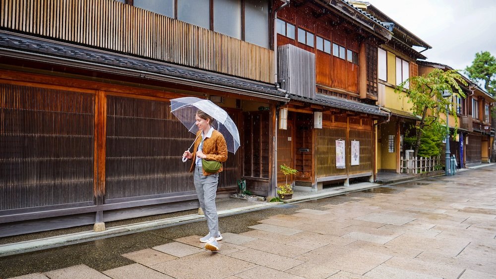 That Backpacker Audrey Bergner visiting Nishi Chaya District with umbrella in hand impressed by the traditional teahouse quarters of Kanazawa, Japan 