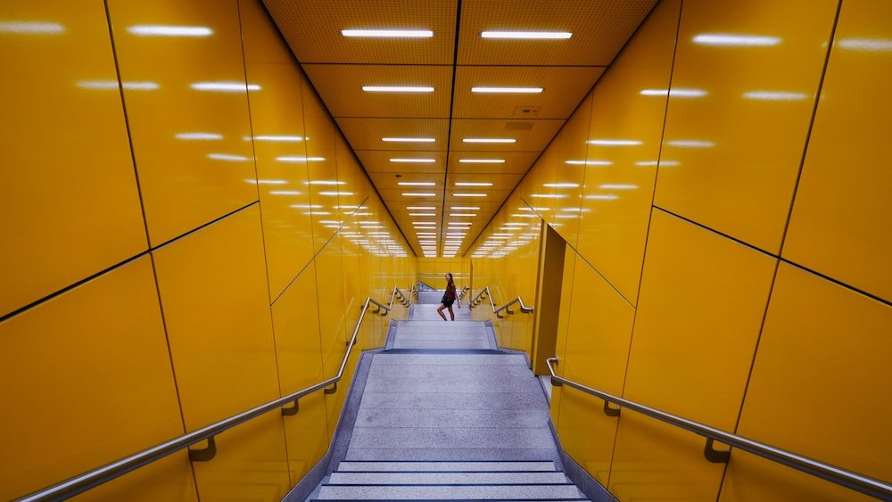 That Backpacker walking down the steps to use Munich public transportation metro system 