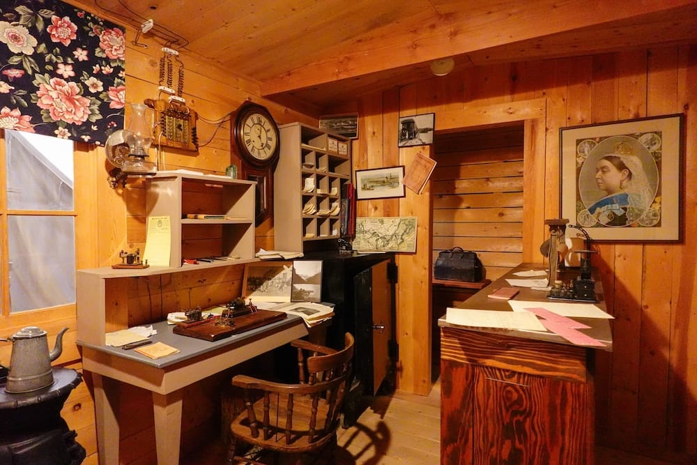 Oficina histórica de The Confluence y antiguo Fort Calgary en Calgary, Alberta, Canadá Oficina histórica recreada en The Confluence, Calgary, Alberta, Canadá, con escritorios de madera, relojes, documentos, mapas, equipos antiguos de comunicación y mobiliario de época.