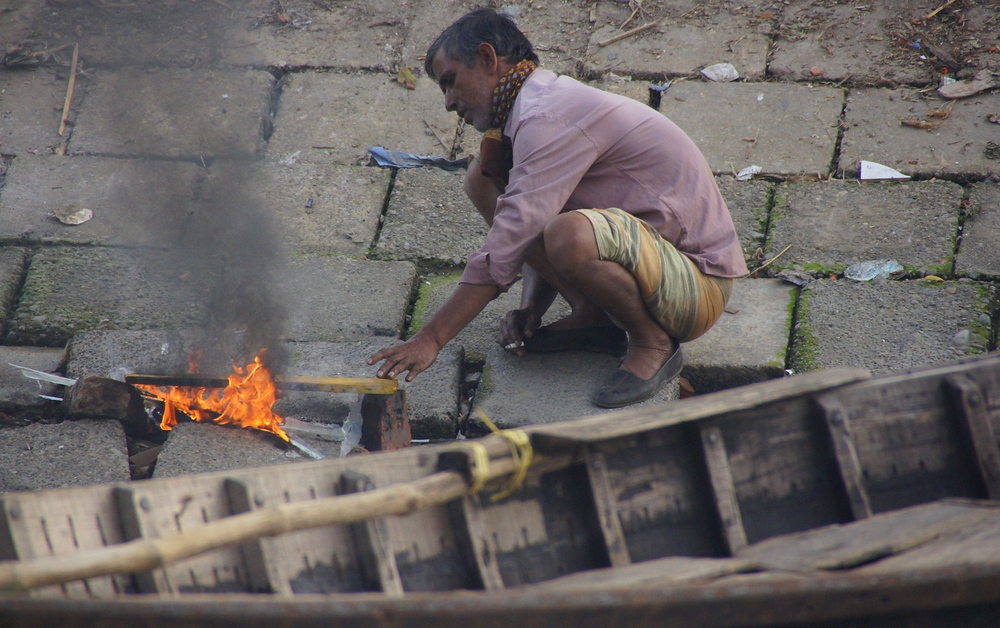 This Bangladeshi man tends to the small fire at the ghat in Old Dhaka, Bangladesh
