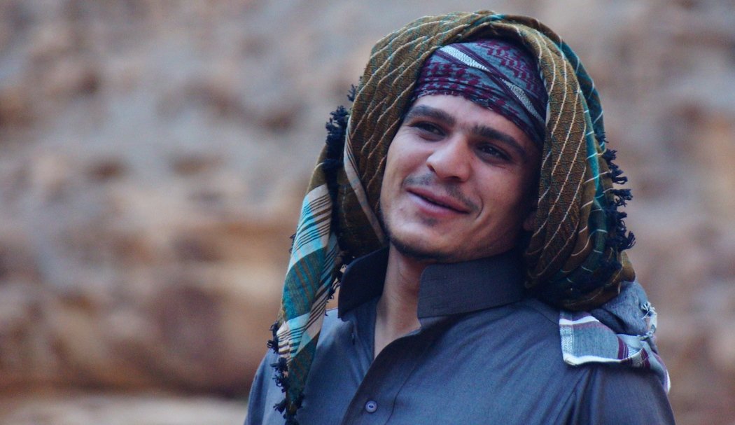 This is a candid portrait of a Bedouin man smiling early in the morning before breakfast.