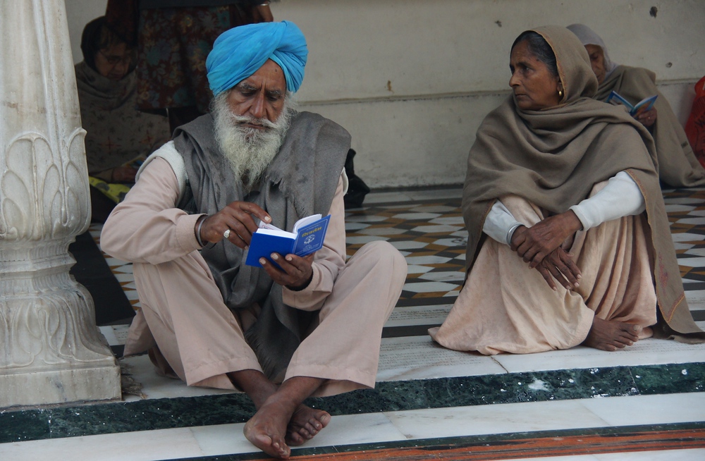 This is a photo of a man sitting down while reading at the Golden Temple