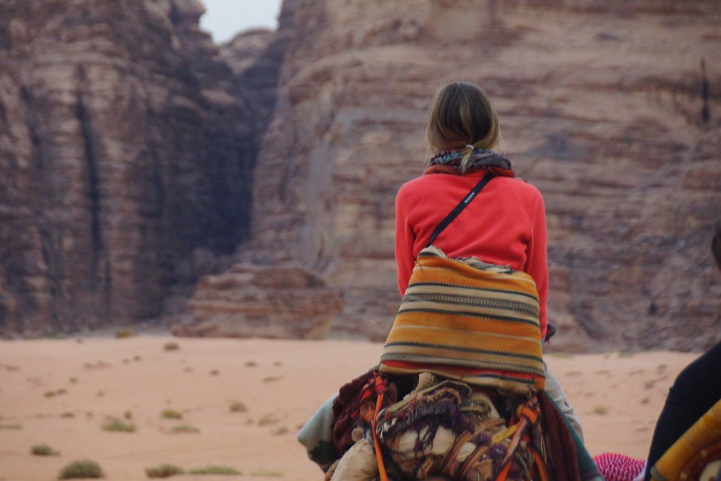 This is a travel image of Audrey Bergner riding a camel for the first time in Wadi Rum, Jordan. She did remarkably well for somebody with very little experience riding animals.