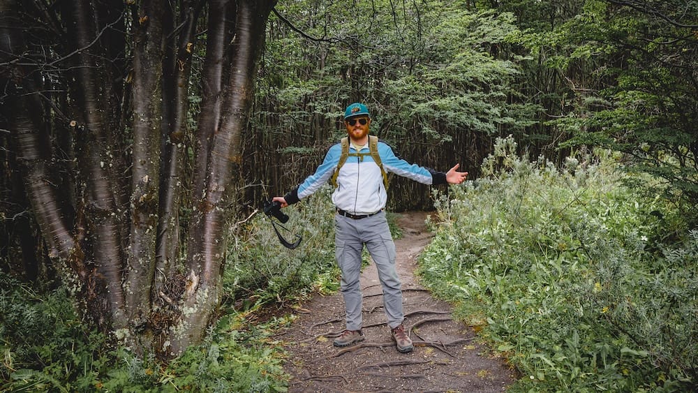 Samuel Jeffery trekking in Tierra del Fuego National Park near Ushuaia on a forest trail that appears manageable but can be misleading for first-time Patagonia visitors who underestimate terrain, roots, and changing conditions