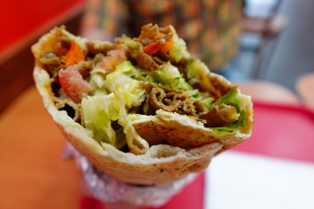 Donair mixto de carne y pollo, Top Donair, Jasper Avenue, Centro de Edmonton, Alberta, Canadá Primer plano de un donair mixto de carne y pollo de Top Donair en Jasper Avenue, en el centro de Edmonton, Alberta, Canadá, que muestra la carne fileteada, lechuga picada y tomate en cubos dentro de un pan pita envuelto en papel aluminio.