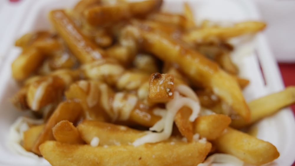 Poutine, Top Donair, Jasper Avenue, Centro de Edmonton, Alberta, Canadá — Papas fritas, gravy y queso derretido Primer plano del poutine de Top Donair en Jasper Avenue, en el centro de Edmonton, Alberta, Canadá, que muestra papas fritas crocantes cubiertas con salsa gravy y queso derretido en lugar de queso en grano (curds).