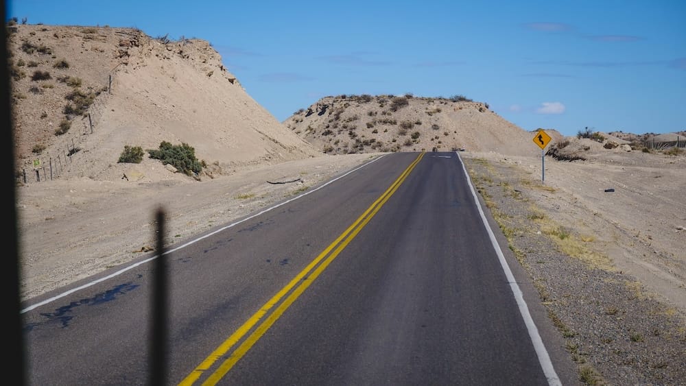 Open road between Trelew, Dolavon, and Gaiman in Patagonia, showing arid landscapes Welsh settlers crossed to establish communities, highlighting the isolation and determination behind preserving their culture in southern Argentina.