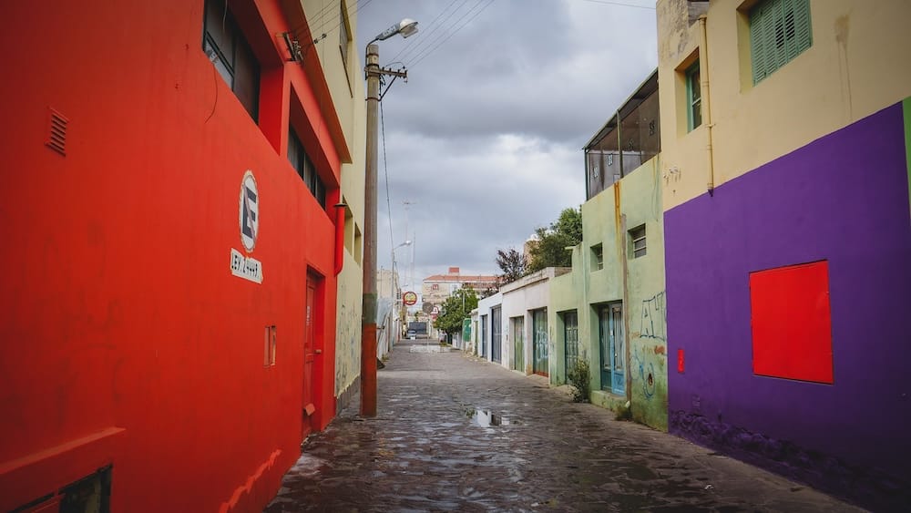 Quiet cobblestone alley in Trelew Patagonia under overcast skies where closures, off-hours downtime, and unpredictable schedules are common, reflecting how weather and seasonal rhythms can slow daily life beyond typical travel expectations.