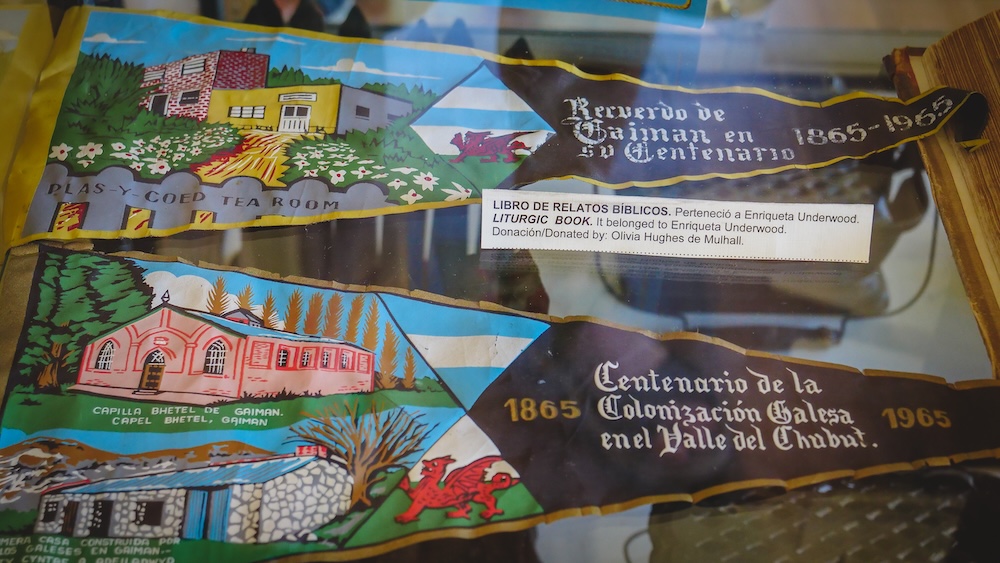 Trelew Patagonia museum display featuring Welsh colonization artifacts commemorating the centenary of Welsh settlement in the Chubut Valley with illustrated banners referencing Gaiman, tea houses, and historic Welsh culture in Patagonia Argentina.