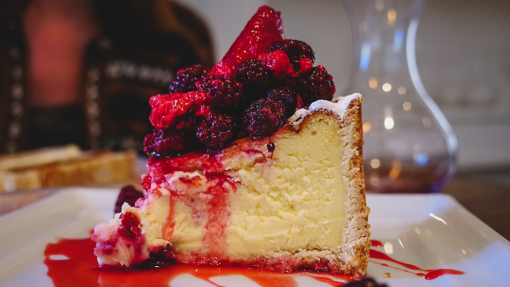 Trelew Patagonia Welsh tea house dessert featuring a rich cheesecake topped with berries and syrup served in Chubut Argentina representing the traditional cake culture associated with Welsh tea houses in Patagonia.