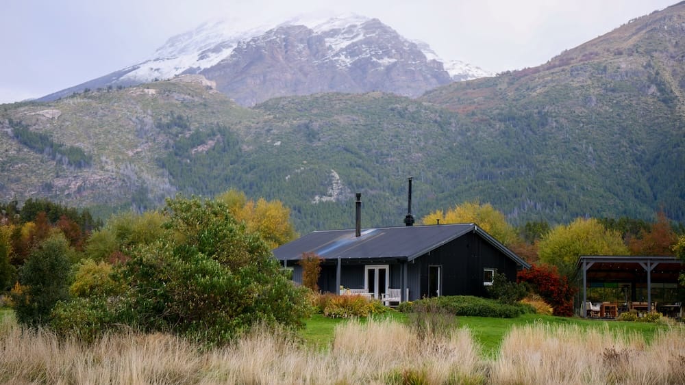 Trevelin Patagonia mountain views Andes landscape Welsh tea region Chubut Argentina countryside Trevelin Patagonia mountain landscape with cozy countryside house surrounded by forest and autumn colors beneath snow-capped Andes peaks in Chubut Argentina, capturing the remote alpine environment shaping Welsh tea culture in the region