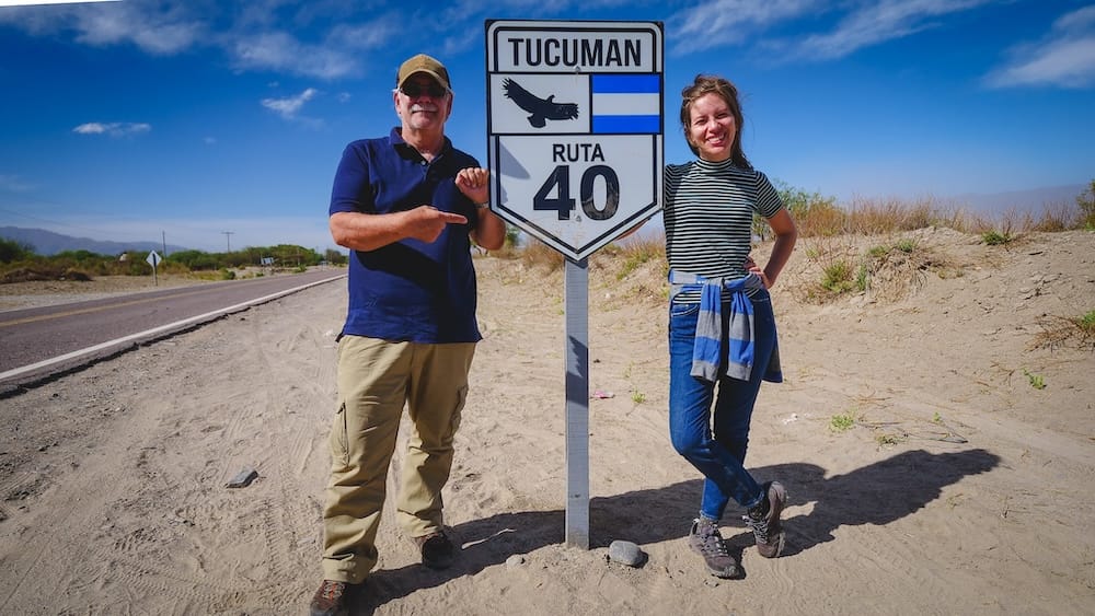Tucumán Ruta 40 roadside fieldwork with Daniel Bergner and Audrey Bergner standing beside the provincial Route 40 sign, documenting northwest Argentina travel logistics, roads, and regional access for Project 23.