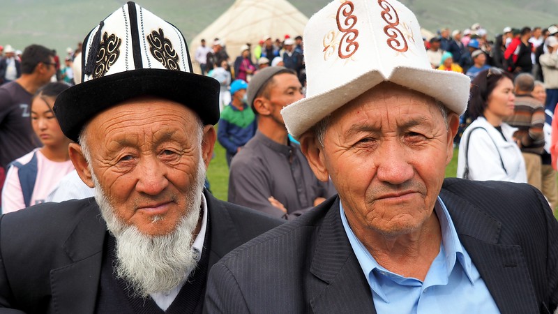 Two Kyrgyz men with distinct faces at the nomad games in Kyrgyzstan