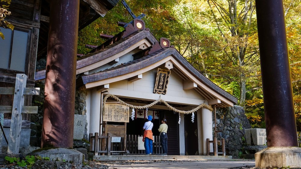 Unique vantage point view of folks showing respect Togakushi Shrine sacred site views on a day trip from Nagano city, Japan 