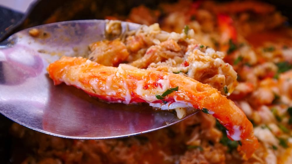 Fresh Southern King Crab meat served on a spoon in Ushuaia, Tierra del Fuego, Argentina, showcasing delicate centolla from the Beagle Channel known for its buttery texture and prized status in Patagonian coastal cuisine.
