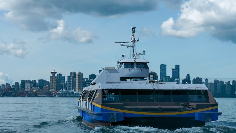 Vancouver Harbour ferry and skyline Passenger ferry cruising across Vancouver Harbour with the downtown skyline and waterfront towers in the background, illustrating a common public transportation option for getting around Vancouver while enjoying coastal city views.
