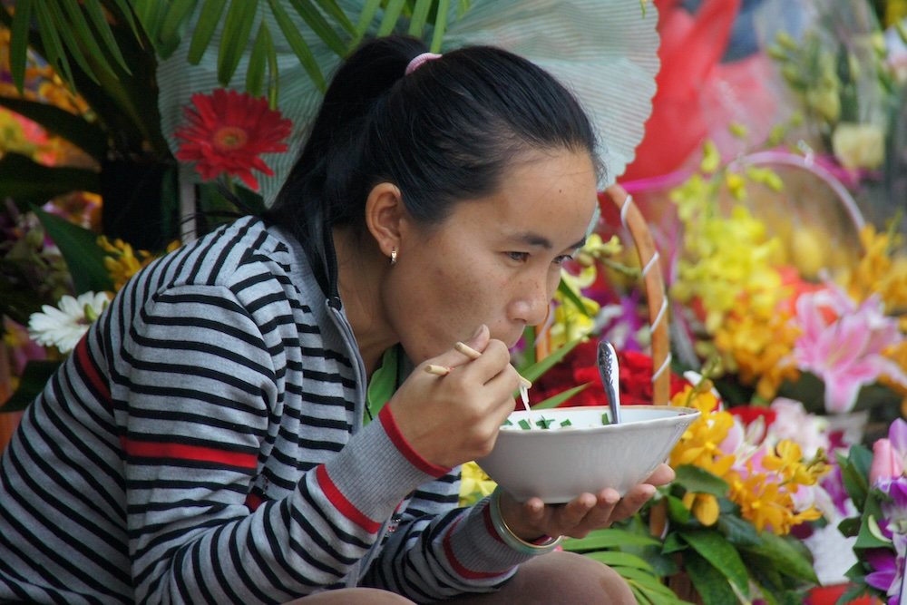 Vietnamese lady enjoying pho for breakfast in Vietnam 